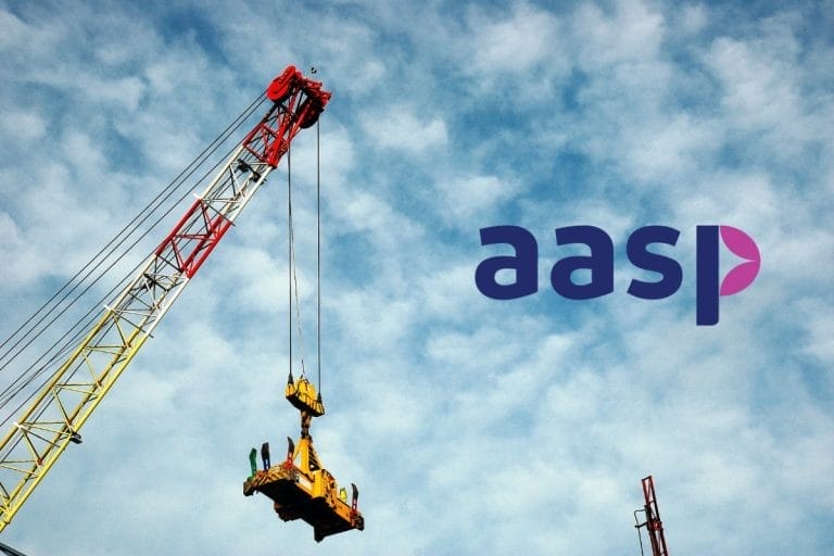 A tall construction crane lifts equipment against a cloudy blue sky. The letters aasp in stylized purple font appear on the right side of the image.