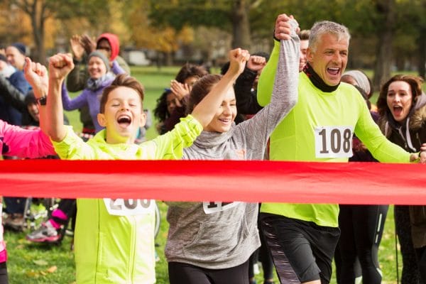 ccs case study header A group of runners, including a smiling man and two children, cross the red finish line holding hands as cheering spectators celebrate—capturing the teamwork and spirit highlighted in this nonprofit case study.