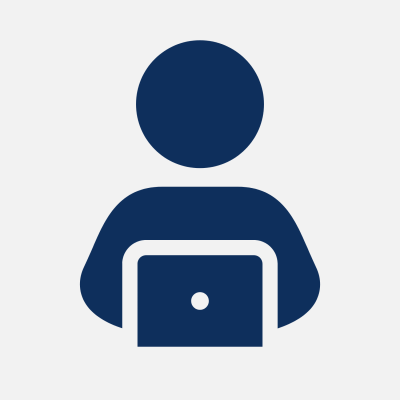 no pic client headshot A simple dark blue icon of a person sitting behind a desk, working on a laptop. The figure is represented with basic shapes on a white background.